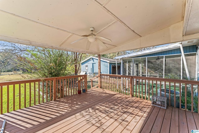 wooden deck featuring a sunroom and ceiling fan