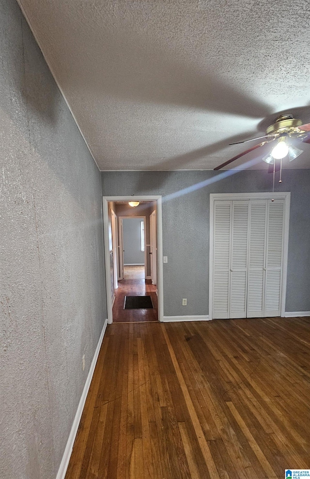 hallway featuring dark hardwood / wood-style flooring and a textured ceiling