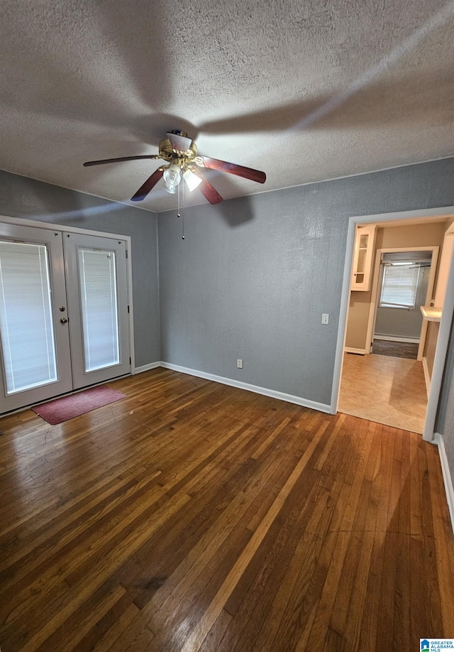 unfurnished bedroom with ceiling fan, french doors, a textured ceiling, and hardwood / wood-style flooring