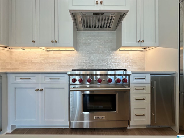 kitchen featuring stainless steel appliances, decorative backsplash, white cabinetry, and extractor fan