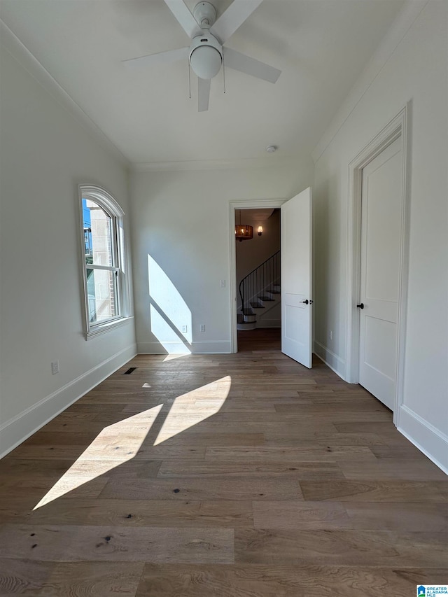 empty room with ceiling fan, light hardwood / wood-style floors, and ornamental molding