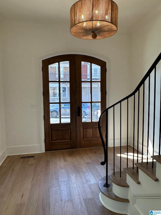 foyer entrance with light hardwood / wood-style floors and french doors