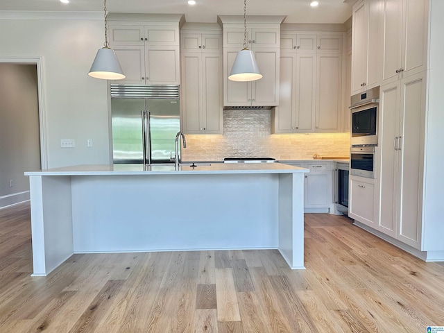 1227 23rd St S Unit B2, Birmingham, AL 35205 - kitchen featuring stainless steel appliances, a sink, light countertops, backsplash, and an island with sink