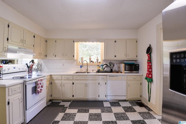 kitchen featuring backsplash, sink, stainless steel appliances, and a textured ceiling