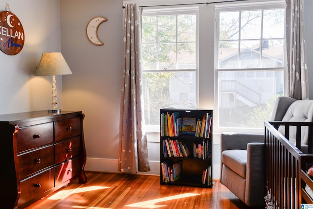 bedroom featuring a nursery area and light hardwood / wood-style floors