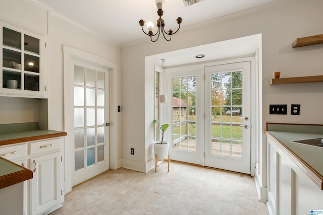 doorway to outside featuring crown molding and a notable chandelier