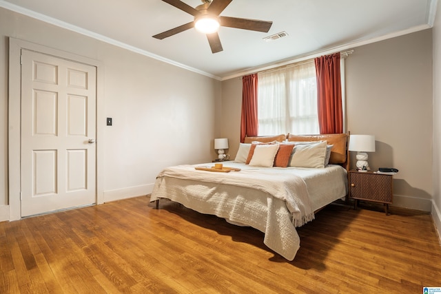 bedroom featuring ceiling fan, wood-type flooring, and crown molding