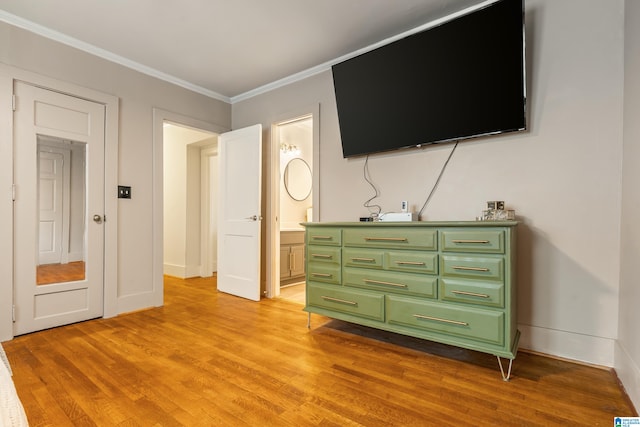 unfurnished bedroom featuring crown molding, ensuite bathroom, and light hardwood / wood-style floors