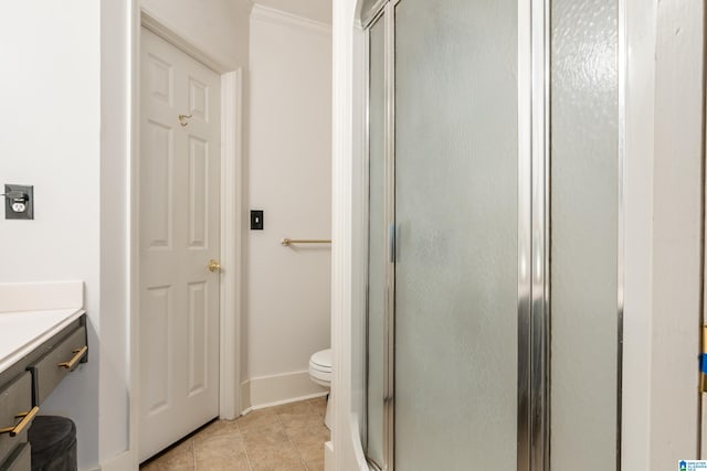 bathroom with ornamental molding, tile patterned floors, a shower with door, vanity, and toilet