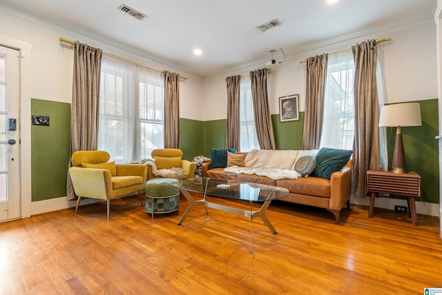 living area featuring light hardwood / wood-style flooring and ornamental molding