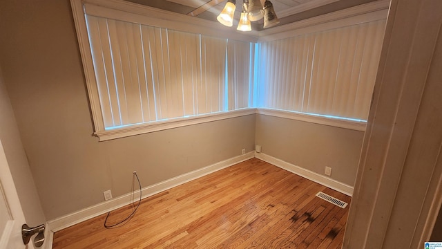 empty room with crown molding and hardwood / wood-style flooring