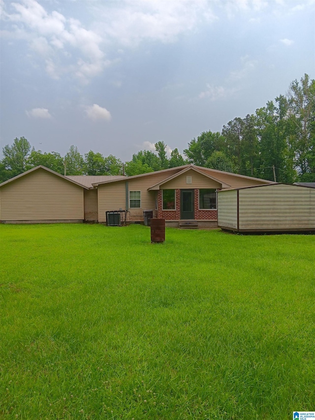 rear view of house featuring a lawn and central air condition unit