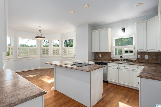 kitchen with white cabinetry, dishwasher, sink, light hardwood / wood-style flooring, and a kitchen island