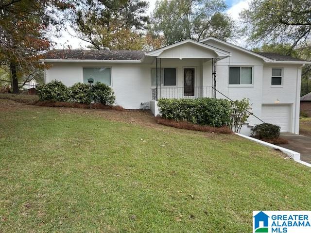 single story home featuring a garage and a front lawn