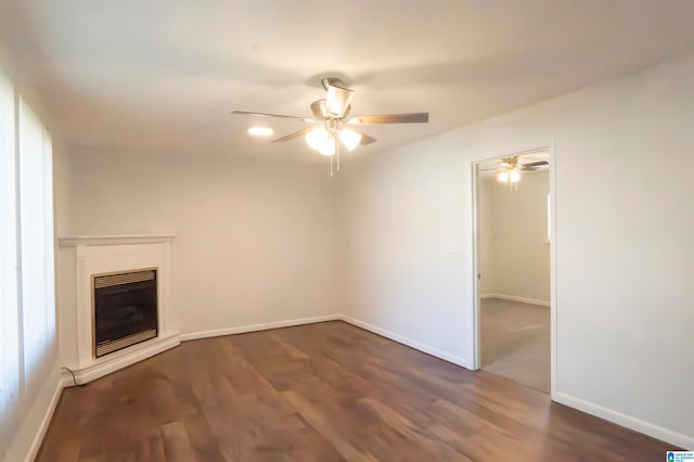 unfurnished living room featuring ceiling fan and dark wood-type flooring