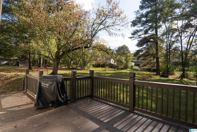 wooden terrace with area for grilling and a yard