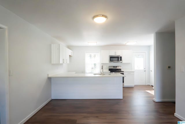 kitchen with white cabinetry, sink, stainless steel appliances, dark wood-type flooring, and kitchen peninsula