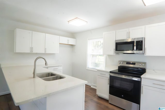 kitchen with light stone countertops, appliances with stainless steel finishes, dark hardwood / wood-style flooring, sink, and white cabinetry