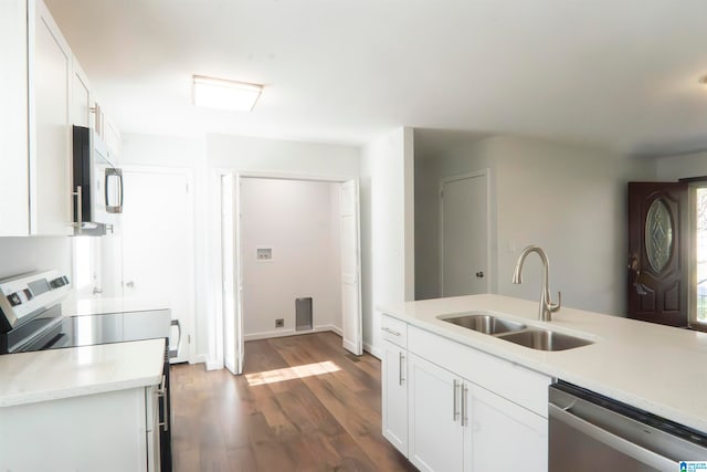 kitchen with stainless steel dishwasher, stove, white cabinetry, and sink