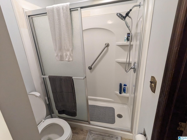 bathroom with an enclosed shower and toilet