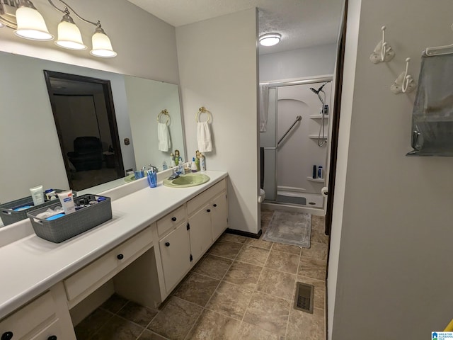 bathroom with a textured ceiling, toilet, a shower, and vanity