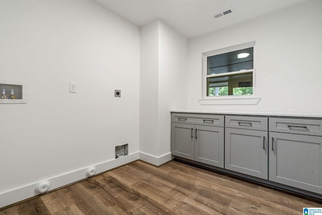 laundry room with hookup for a washing machine, cabinets, dark hardwood / wood-style floors, and hookup for an electric dryer