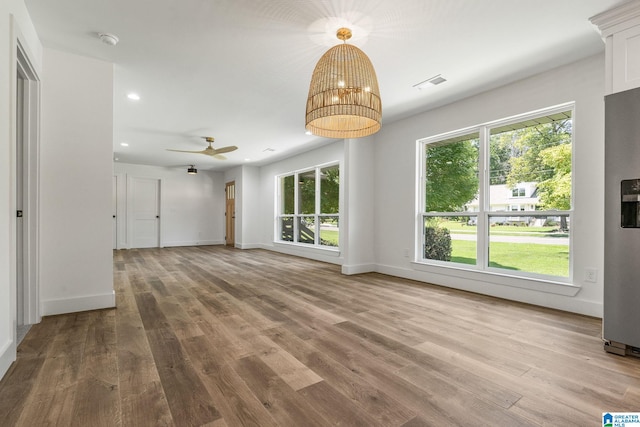 unfurnished living room featuring a wealth of natural light, hardwood / wood-style floors, and ceiling fan