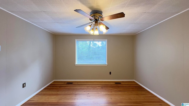 spare room with wood-type flooring, ceiling fan, and ornamental molding