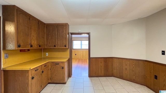 kitchen featuring wood walls and light tile patterned flooring