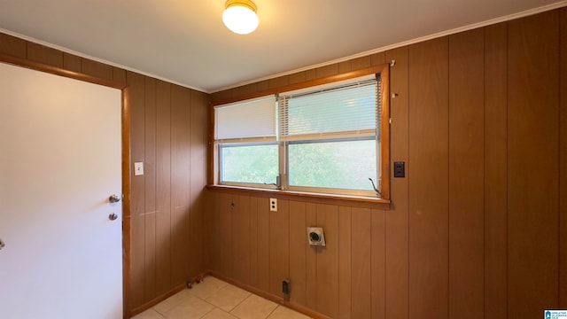 laundry room featuring hookup for an electric dryer, light tile patterned floors, and wood walls