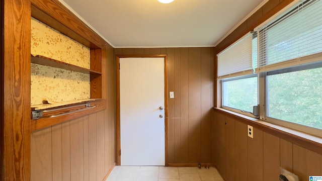 entryway featuring wooden walls and light tile patterned flooring