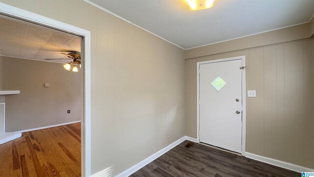 foyer with ceiling fan, dark wood-type flooring, and crown molding