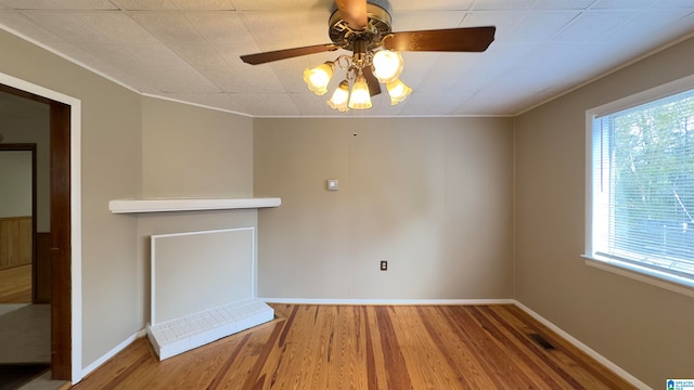 unfurnished living room with ceiling fan, wood-type flooring, and ornamental molding