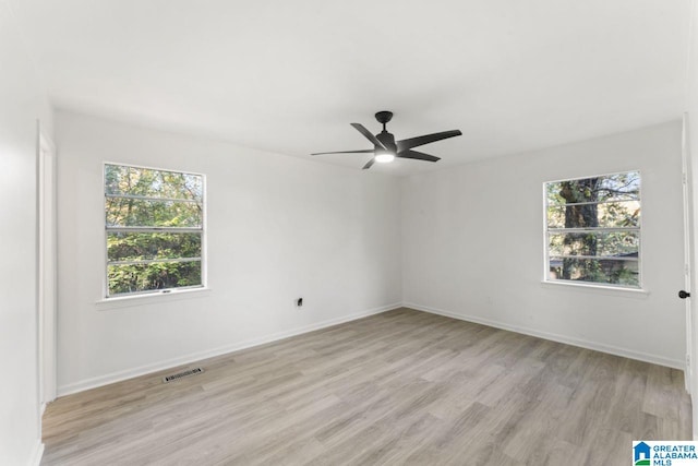 spare room with light hardwood / wood-style flooring, a wealth of natural light, and ceiling fan