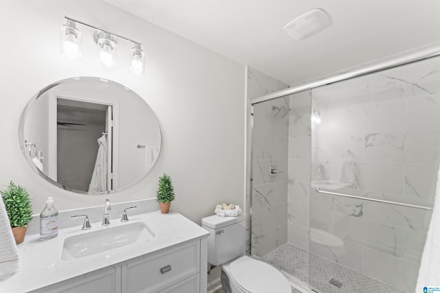 bathroom featuring vanity, toilet, and an enclosed shower