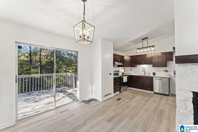 kitchen with stainless steel appliances, vaulted ceiling, hanging light fixtures, and sink