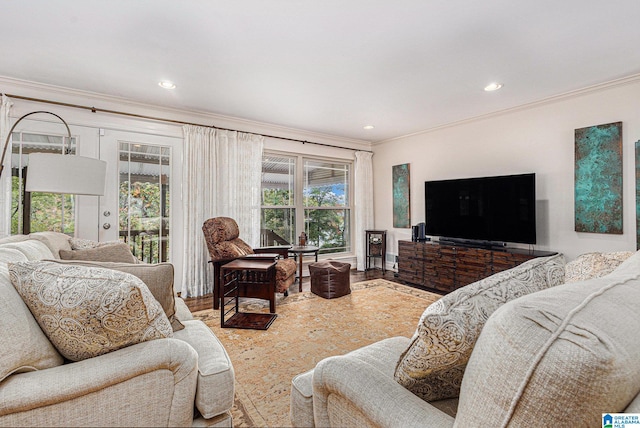 living room featuring wood-type flooring, plenty of natural light, and ornamental molding