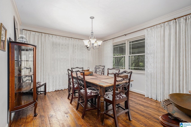 dining room featuring dark hardwood / wood-style flooring, an inviting chandelier, and ornamental molding