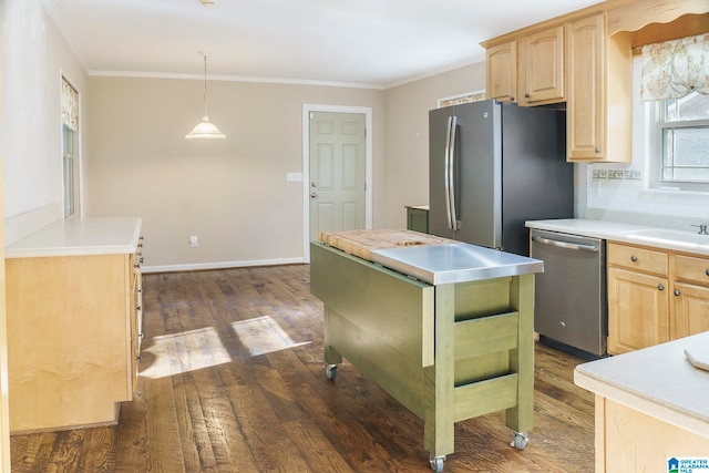 kitchen with light brown cabinetry, decorative light fixtures, a kitchen island, dark hardwood / wood-style flooring, and stainless steel appliances