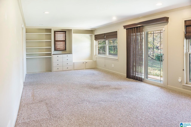 unfurnished bedroom featuring light colored carpet, crown molding, and access to outside