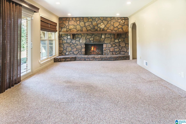 unfurnished living room with a fireplace, carpet floors, a wealth of natural light, and crown molding