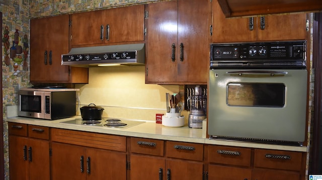 kitchen with oven, white electric cooktop, and ventilation hood