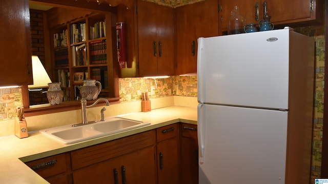 kitchen with backsplash, sink, and white refrigerator