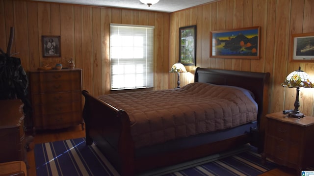 bedroom with dark wood-type flooring and wood walls