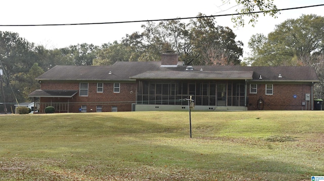 back of property featuring a sunroom and a yard