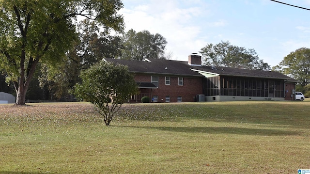 view of front of property with a front yard, a sunroom, and central AC unit