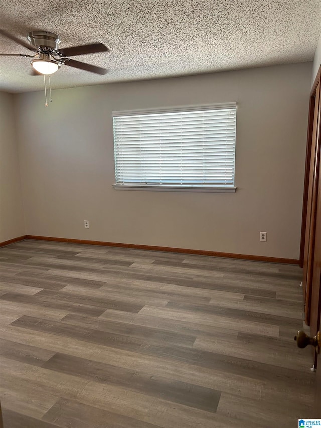 spare room with ceiling fan, dark hardwood / wood-style flooring, and a textured ceiling