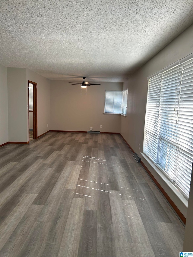 unfurnished room with ceiling fan, hardwood / wood-style flooring, and a textured ceiling