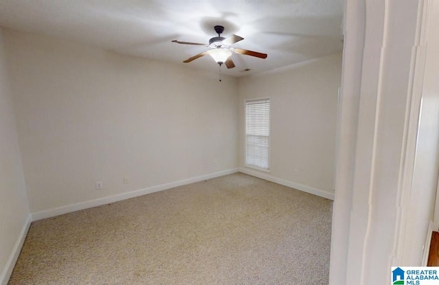 carpeted spare room with ceiling fan