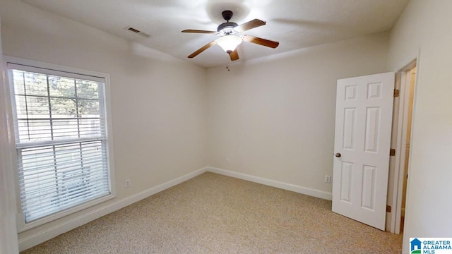 empty room with ceiling fan and light carpet